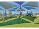 Playground with vibrant play equipment, including swings, climbing structures, and a covered seating area for  at 1696 Wilson Prairie Cir, Groveland, FL 34736