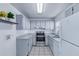 Well-lit kitchen with clean gray cabinets, stainless steel appliances, and tiled backsplash at 1726 Tropical Ct, Tavares, FL 32778
