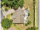 The aerial view shows a home with a screened pool and patio, set amongst mature trees and lush landscaping at 17300 Summer Sun Ct, Clermont, FL 34711