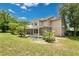 Lovely backyard with a screened-in pool, lush landscaping, and a view of the home's exterior at 17300 Summer Sun Ct, Clermont, FL 34711