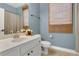 Bathroom with a vanity, toilet, decorative mirror, and window with natural light at 17300 Summer Sun Ct, Clermont, FL 34711