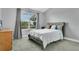 This carpeted bedroom is neutral colored with a window and wood dresser at 17300 Summer Sun Ct, Clermont, FL 34711