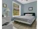 Cozy bedroom with neutral walls, wood look tile floors, and window letting in plenty of natural light at 17300 Summer Sun Ct, Clermont, FL 34711