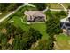 Aerial view of a sprawling lawn, lush trees, and pool in a screened enclosure at the rear of the home at 18008 Victorian Dr, Clermont, FL 34715