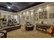 Basement living space with leather reclining sofas, and a piano adjacent to the basement stairs at 18008 Victorian Dr, Clermont, FL 34715
