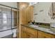 Bathroom featuring glass-door shower, tile, granite counter and wood cabinetry for storage at 18008 Victorian Dr, Clermont, FL 34715