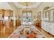 Formal dining room featuring colorful rug, chandelier, and adjacent kitchen at 18008 Victorian Dr, Clermont, FL 34715