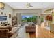 Open-concept living room with hardwood floors, comfortable sofas, and backyard pool view at 18008 Victorian Dr, Clermont, FL 34715