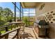 Outdoor kitchen area with a built-in grill, dining table, and lush greenery at 18008 Victorian Dr, Clermont, FL 34715