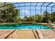 Enclosed pool with lush landscaping, a waterfall feature, and a tanning deck at 18008 Victorian Dr, Clermont, FL 34715
