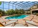 Screened-in pool area with lounge chairs and an outdoor dining space at 18008 Victorian Dr, Clermont, FL 34715