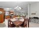 Cozy dining area with wood table, chandelier, and open view to kitchen and living room, perfect for Gathering meals and entertaining at 1815 Kaufman Cir, Lady Lake, FL 32159