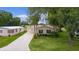 Charming single-story home with a well-maintained lawn, mature trees, and an inviting carport at 1815 Kaufman Cir, Lady Lake, FL 32159