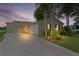 Home exterior showing the driveway, carport, and well-lit landscape at dusk at 1815 Kaufman Cir, Lady Lake, FL 32159