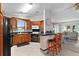 Open-concept kitchen with wood cabinets, breakfast bar, stainless steel appliances, flowing into a sunny living area at 1815 Kaufman Cir, Lady Lake, FL 32159