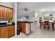 Open concept kitchen with wood cabinets and a breakfast bar that is next to the dining room at 1815 Kaufman Cir, Lady Lake, FL 32159