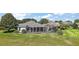 Backyard aerial view of the screened lanai, landscaping, and green grass at 1920 Iglesia St, The Villages, FL 32159