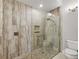 Bathroom featuring glass enclosed walk-in shower with pebble flooring and tiled walls at 1920 Iglesia St, The Villages, FL 32159