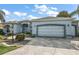 Stylish home with arched entryway, modern garage door, and well-maintained landscaping at 1920 Iglesia St, The Villages, FL 32159