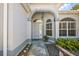 Charming front entrance with a secure gate, decorative stone path, and lush landscaping at 1920 Iglesia St, The Villages, FL 32159