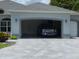 Charming home featuring a paver driveway and a two-car garage with a blue truck parked inside at 1920 Iglesia St, The Villages, FL 32159