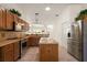 Well-lit kitchen featuring stainless steel appliances and an island with a breakfast bar and granite countertops at 1920 Iglesia St, The Villages, FL 32159