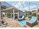Inviting screened lanai with ample seating, stone floors, and access to the outdoors at 1920 Iglesia St, The Villages, FL 32159