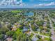 Aerial view of the neighborhood, showcasing tree-lined streets, a serene lake, and well-maintained homes at 206 Palermo Pl, Lady Lake, FL 32159
