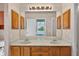Bathroom features dual sinks, wood cabinets, vanity and decorative light fixture at 206 Palermo Pl, Lady Lake, FL 32159