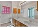 Bathroom features a double sink vanity, wood cabinets and pink shutters on the window at 206 Palermo Pl, Lady Lake, FL 32159