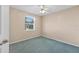 Bedroom features a ceiling fan, window overlooking trees and neutral carpet at 206 Palermo Pl, Lady Lake, FL 32159