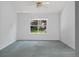 An empty bedroom with neutral walls features a window overlooking the front yard at 206 Palermo Pl, Lady Lake, FL 32159