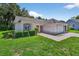 Lovely single-story home with manicured lawn, mature landscaping, and a side entry two-car garage at 206 Palermo Pl, Lady Lake, FL 32159