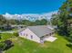 Rear exterior view showing a home with a neutral-colored exterior, green roof, and well-manicured lawn at 206 Palermo Pl, Lady Lake, FL 32159
