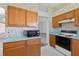 Kitchen with wood cabinets, electric range, overhead vent, and blue countertops at 206 Palermo Pl, Lady Lake, FL 32159