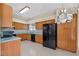 Eat-in kitchen featuring floral wallpaper, wood cabinets and updated black appliances at 206 Palermo Pl, Lady Lake, FL 32159