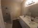 Modern bathroom features dual sinks, a toilet, and walk-in glass-enclosed shower at 222 Bacopa Pass, Davenport, FL 33897