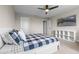 Neutral bedroom with a ceiling fan, a large bed with pillows, a television, and a view into the hallway at 2330 Nuthatch St, St Cloud, FL 34771