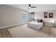 Bright bedroom featuring a ceiling fan, large carpeted area, a wall art, and window view at 2330 Nuthatch St, St Cloud, FL 34771