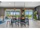 Dining area with a rustic table and chairs and large windows offering scenic lake views and access to an outdoor patio at 2330 Nuthatch St, St Cloud, FL 34771
