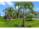 Charming home exterior with well-manicured lawn, lush landscaping, and palm trees at 2330 Nuthatch St, St Cloud, FL 34771