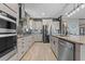 Modern kitchen with stainless steel appliances, granite countertops, ample cabinetry, and stylish lighting fixtures at 2330 Nuthatch St, St Cloud, FL 34771