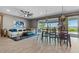 Bright open-concept living room and dining area with a ceiling fan, tile floors, and large windows overlooking the lake at 2330 Nuthatch St, St Cloud, FL 34771