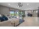 Spacious living room with tile floors, a ceiling fan, comfortable seating, and views of the kitchen and lake at 2330 Nuthatch St, St Cloud, FL 34771