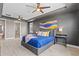 Bright main bedroom featuring a tray ceiling, ceiling fan, en suite access and modern decor at 2330 Nuthatch St, St Cloud, FL 34771