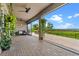 Covered patio with ceiling fans, hanging plants, and a peaceful outdoor view at 2330 Nuthatch St, St Cloud, FL 34771
