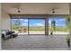 Covered patio with brick flooring, ceiling fans, and comfortable seating overlooking the lake at 2330 Nuthatch St, St Cloud, FL 34771