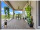 Covered outdoor patio with brick flooring and lush hanging plants perfect for outdoor dining at 2330 Nuthatch St, St Cloud, FL 34771