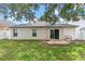 Backyard view showing the exterior of the home, a small patio and partial grass at 2336 Martins Run, Tavares, FL 32778