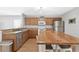 Well-lit kitchen with wooden cabinetry, stainless steel appliances and bar stool seating at 2336 Martins Run, Tavares, FL 32778